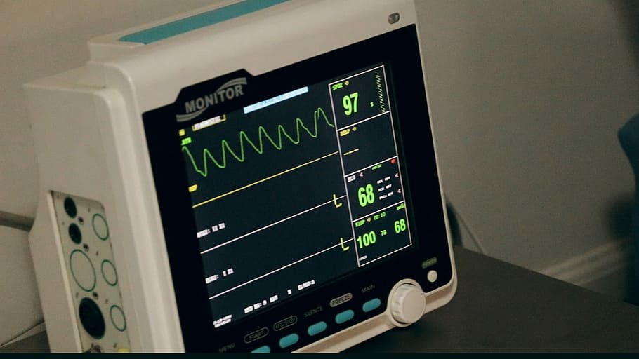 Close-up of a medical monitor displaying a heart rate of 97, blood pressure of 100/68, and other vital signs.
