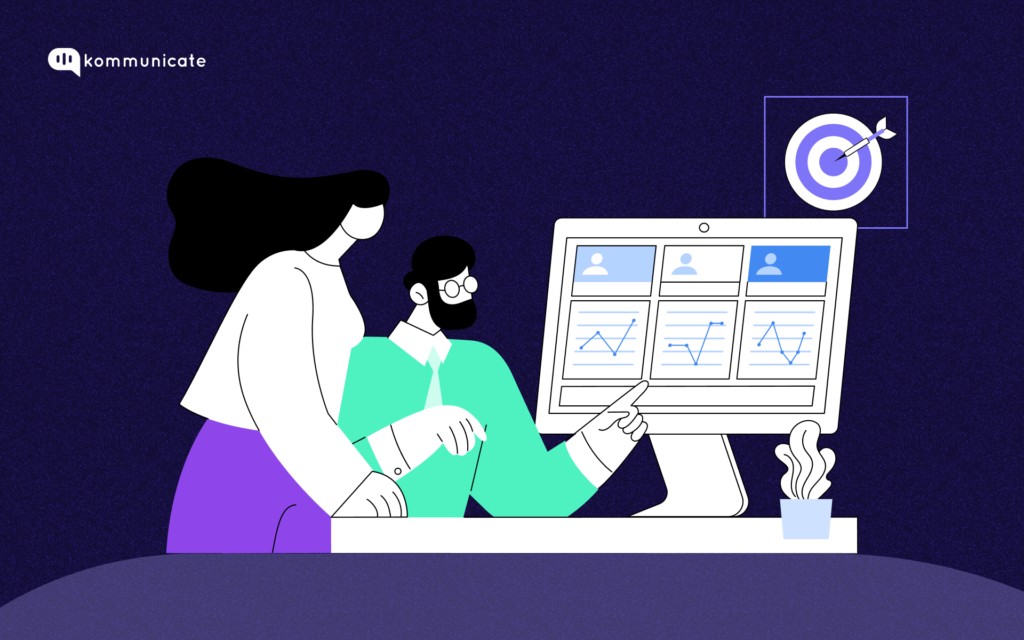 The image shows two people (one with long dark hair and the other with short dark hair and glasses) working together at a desk. They are analyzing data on a computer screen that displays charts and graphs. A target with a dart hitting the bullseye is visible in the top-right corner, symbolizing goal achievement or success. The background is dark with a purple and white color scheme.
